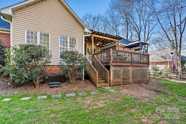 back of property with brick siding, a yard, stairway, and a wooden deck