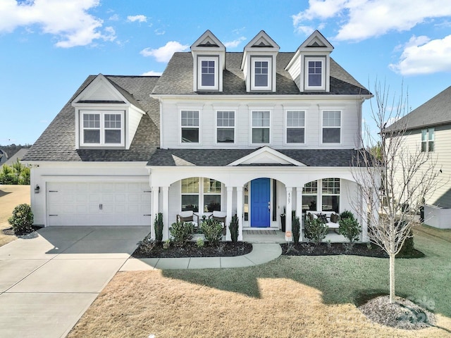 view of front of home featuring a garage, a porch, driveway, and roof with shingles