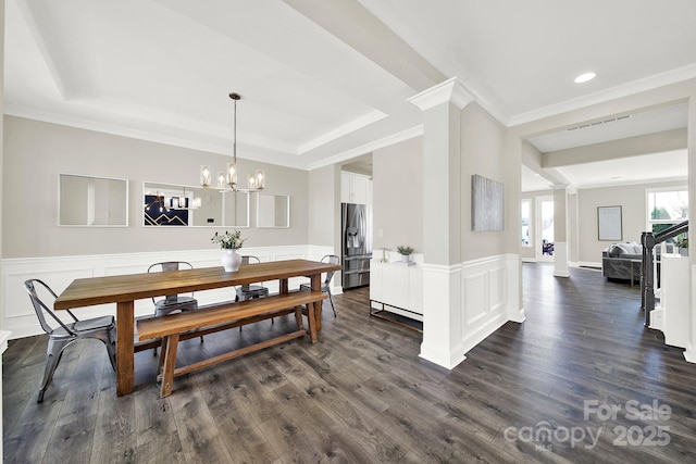 dining room with a tray ceiling, dark wood-style floors, and wainscoting