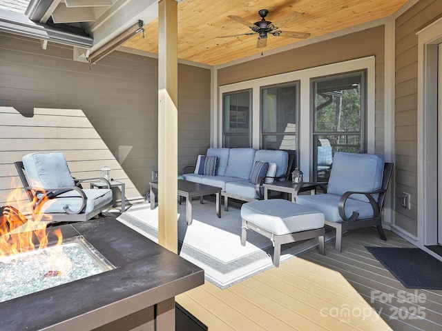 deck with ceiling fan and an outdoor living space with a fire pit