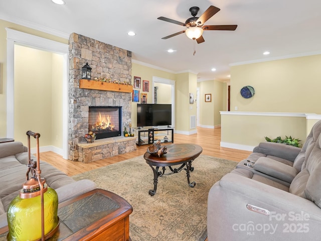 living room featuring ornamental molding, visible vents, a fireplace, and wood finished floors