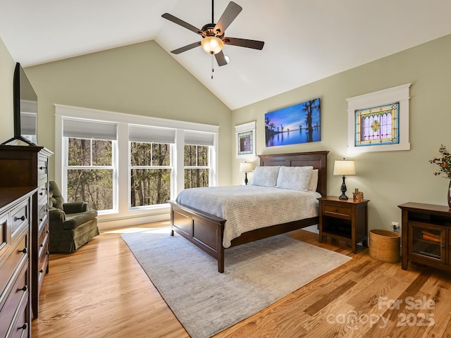 bedroom featuring a ceiling fan, high vaulted ceiling, and light wood-style flooring