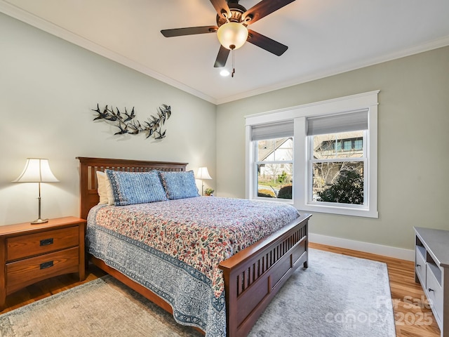 bedroom featuring light wood-type flooring, crown molding, baseboards, and ceiling fan