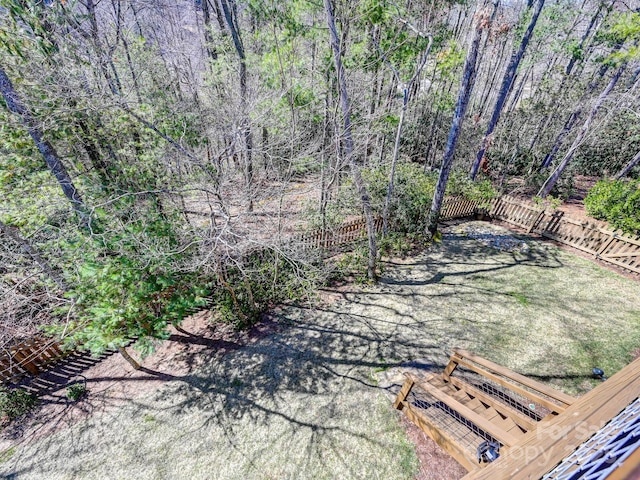 view of yard with fence and a view of trees