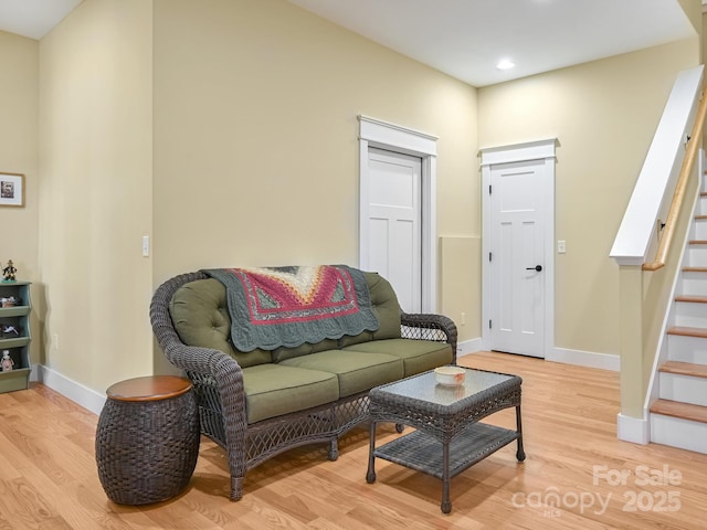 living area with light wood-style flooring, stairway, baseboards, and recessed lighting