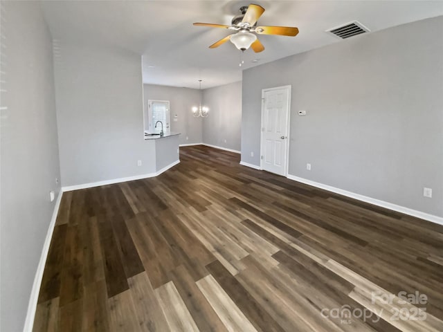 unfurnished living room with baseboards, visible vents, and dark wood-style flooring