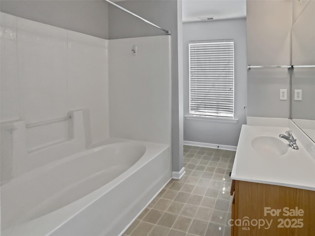 bathroom featuring shower / bathing tub combination, tile patterned flooring, vanity, and baseboards