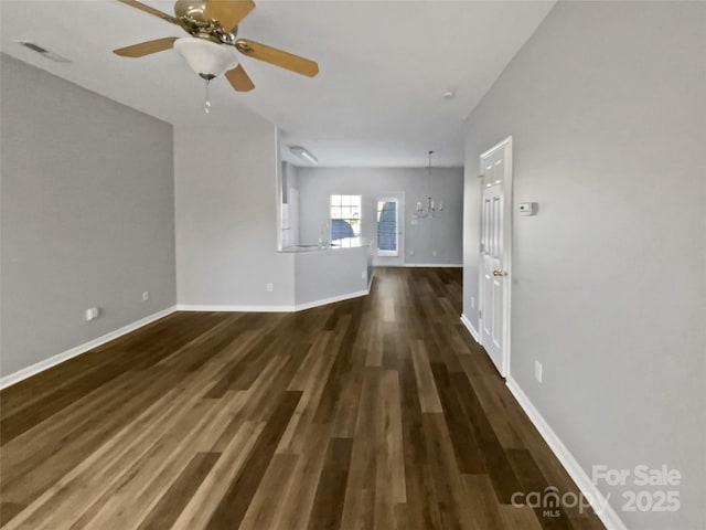 unfurnished living room with baseboards, visible vents, ceiling fan, and dark wood-type flooring