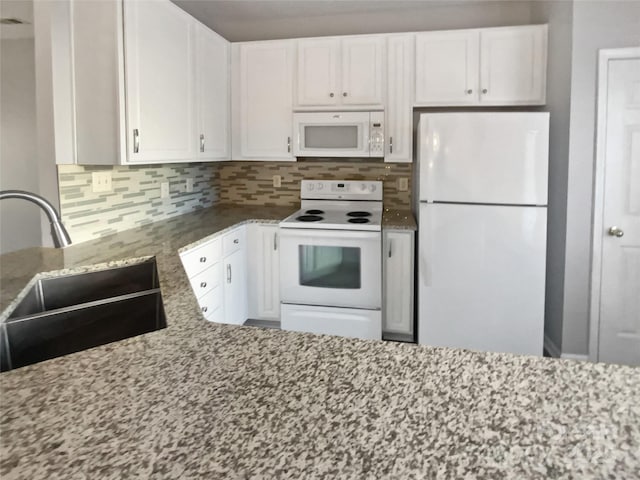 kitchen featuring white appliances, white cabinetry, a sink, and backsplash