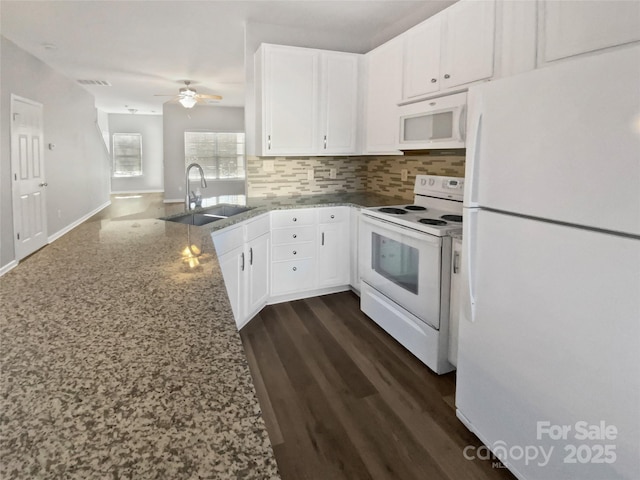 kitchen featuring light stone counters, white appliances, a sink, white cabinets, and backsplash