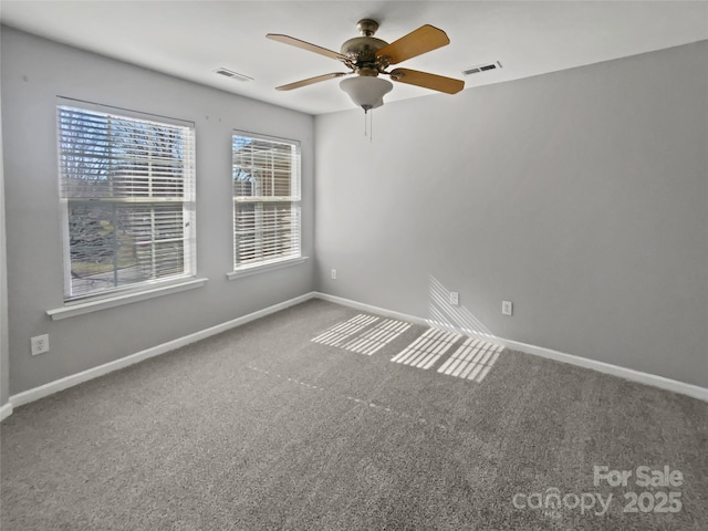 carpeted empty room featuring baseboards, visible vents, and a ceiling fan