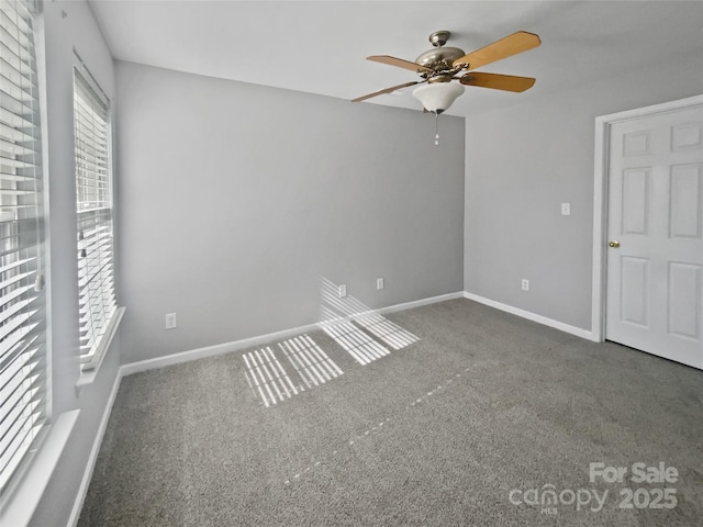 unfurnished bedroom with dark carpet, baseboards, and ceiling fan