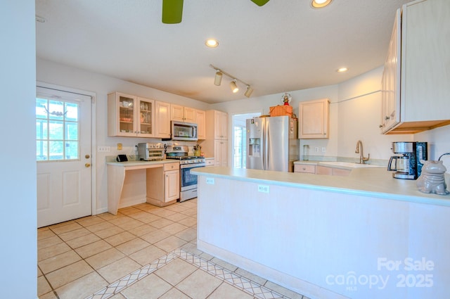 kitchen with light tile patterned floors, recessed lighting, appliances with stainless steel finishes, a sink, and a peninsula