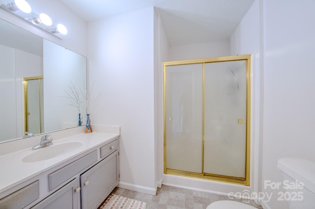 bathroom featuring baseboards, a shower stall, toilet, and vanity