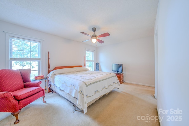 bedroom with baseboards, a ceiling fan, and light colored carpet