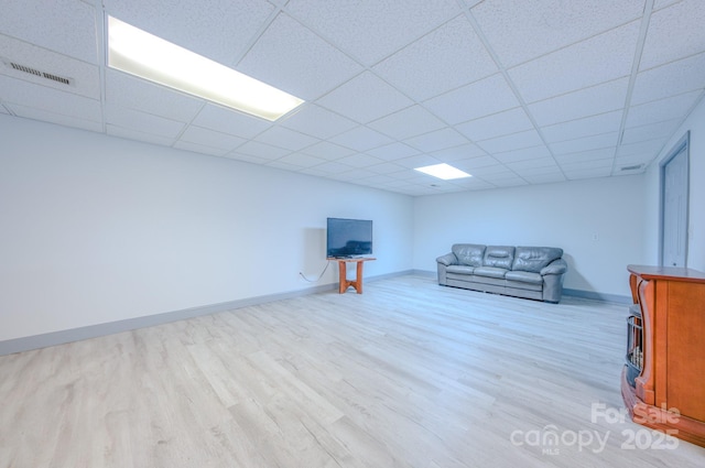 unfurnished living room featuring visible vents, baseboards, a drop ceiling, and wood finished floors