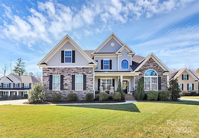 craftsman-style house with stone siding, a front lawn, and a porch