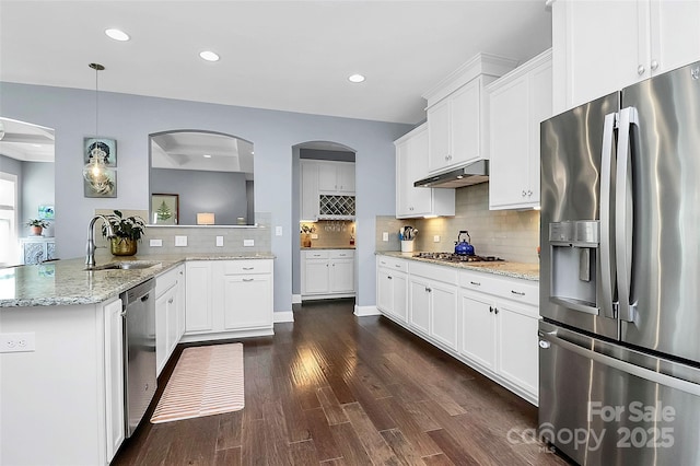 kitchen featuring stainless steel appliances, hanging light fixtures, white cabinets, a peninsula, and under cabinet range hood