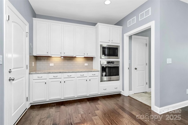 kitchen with appliances with stainless steel finishes, visible vents, and white cabinets