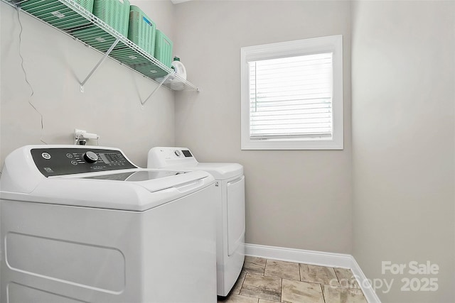 washroom featuring laundry area, washing machine and dryer, and baseboards