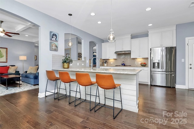 kitchen with pendant lighting, white cabinetry, a sink, and stainless steel refrigerator with ice dispenser