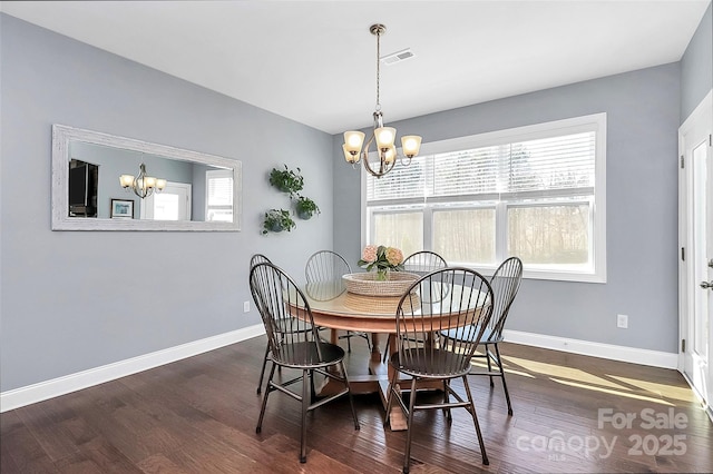 dining area featuring visible vents, dark wood finished floors, baseboards, and an inviting chandelier