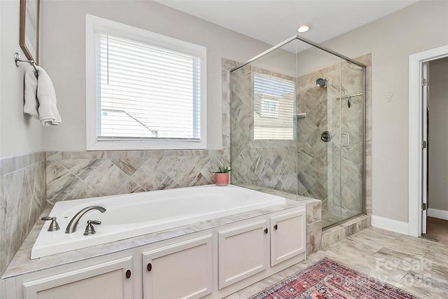 full bath with a shower stall, baseboards, and a bath