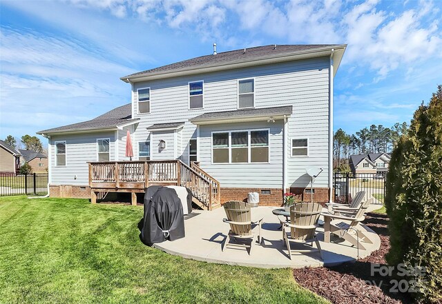 rear view of property featuring a deck, crawl space, fence, and a lawn