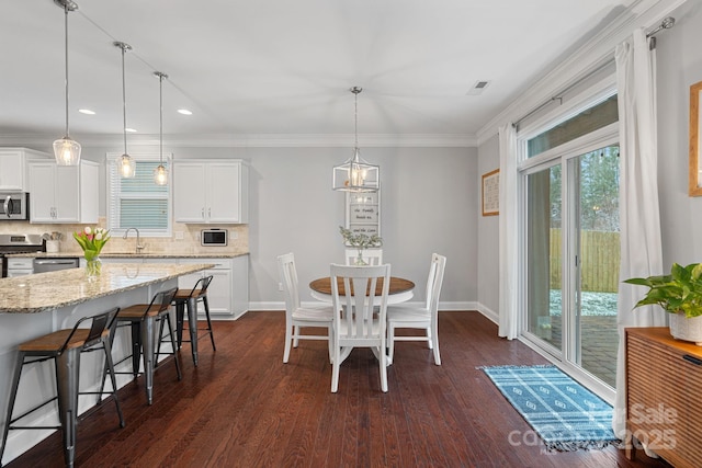 dining room with dark wood-style floors, baseboards, ornamental molding, and recessed lighting