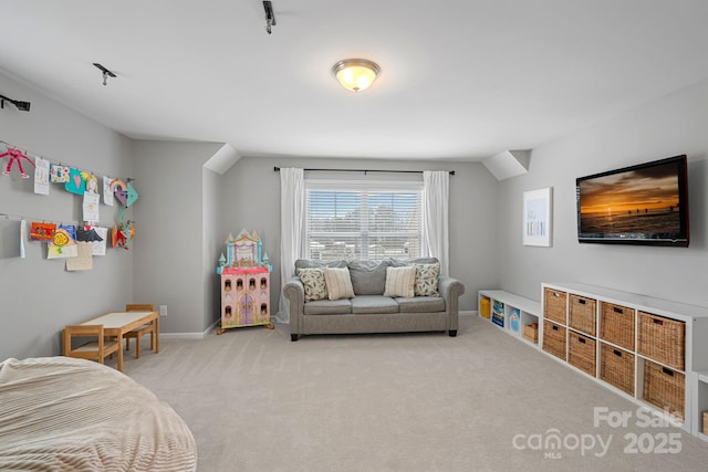 bedroom with vaulted ceiling, baseboards, and light colored carpet