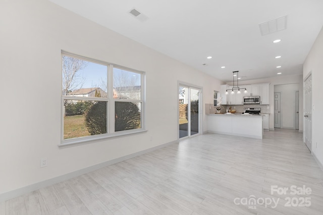 unfurnished living room with recessed lighting, visible vents, and baseboards