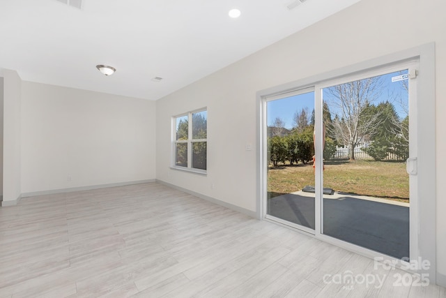 empty room featuring light wood-type flooring and baseboards