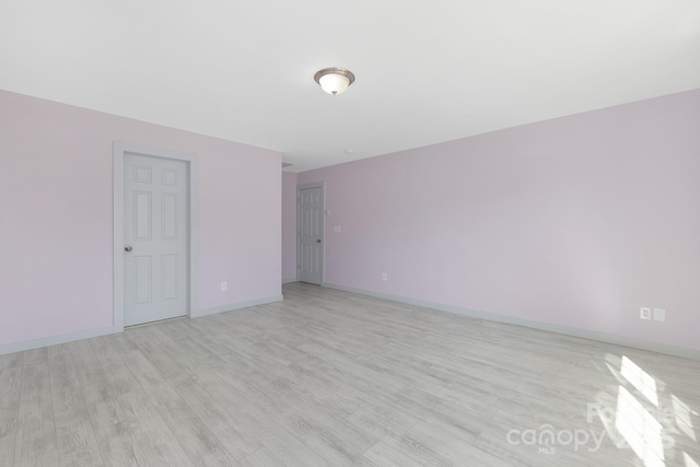 spare room with light wood finished floors and baseboards