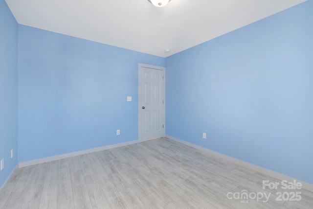 empty room with light wood-type flooring and baseboards