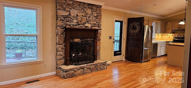 living room featuring a fireplace, light wood-style floors, and ornamental molding