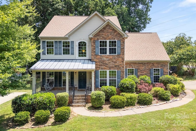 329 Squirrel Ln, Clover, SC 29710 - view of front facade with covered porch, stone siding, a front lawn, a shingled roof, and a standing seam roof