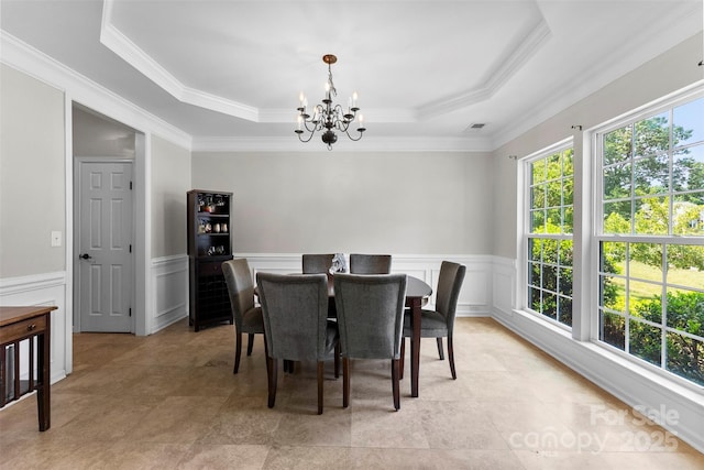 329 Squirrel Ln, Clover, SC 29710 - dining area with a chandelier, a raised ceiling, wainscoting, crown molding, and a decorative wall