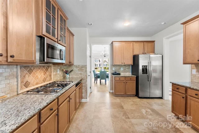 329 Squirrel Ln, Clover, SC 29710 - kitchen with stainless steel appliances, backsplash, light stone counters, glass insert cabinets, and recessed lighting