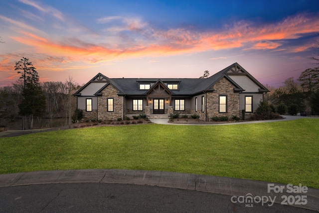 view of front of house with stone siding and a yard