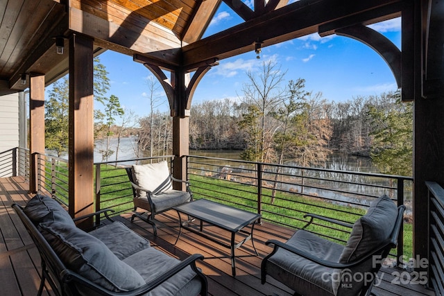 wooden deck with a lawn and a water view