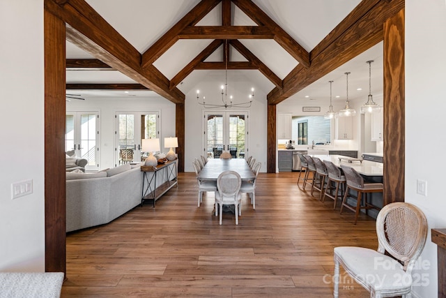 dining space with beam ceiling, french doors, a notable chandelier, and wood finished floors