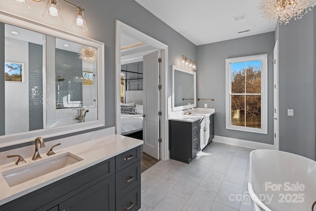 ensuite bathroom featuring visible vents, two vanities, a sink, and ensuite bathroom