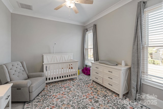 bedroom with a nursery area, multiple windows, visible vents, and crown molding