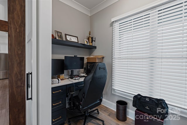 home office featuring light wood-style flooring, ornamental molding, and baseboards