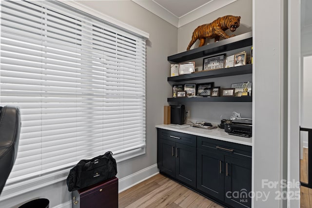 bar featuring crown molding, light wood finished floors, and baseboards