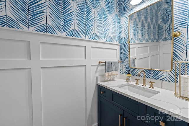 bathroom with vanity and wallpapered walls