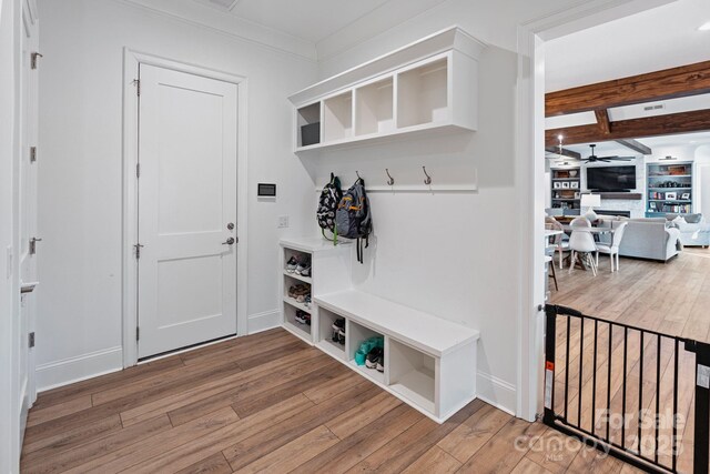 mudroom featuring ornamental molding, ceiling fan, wood finished floors, beamed ceiling, and baseboards