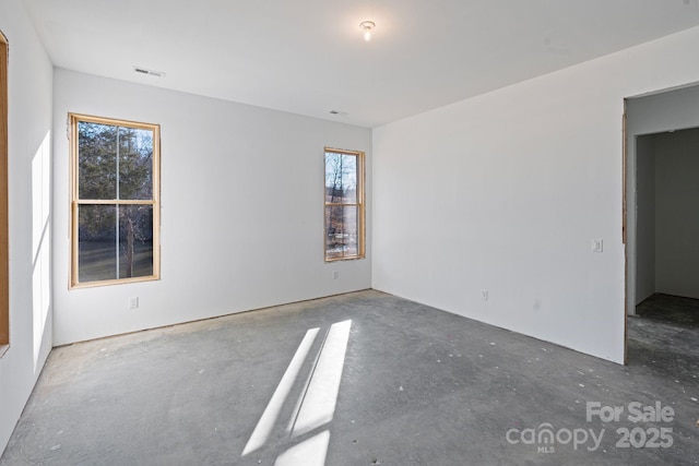 unfurnished room featuring plenty of natural light and visible vents