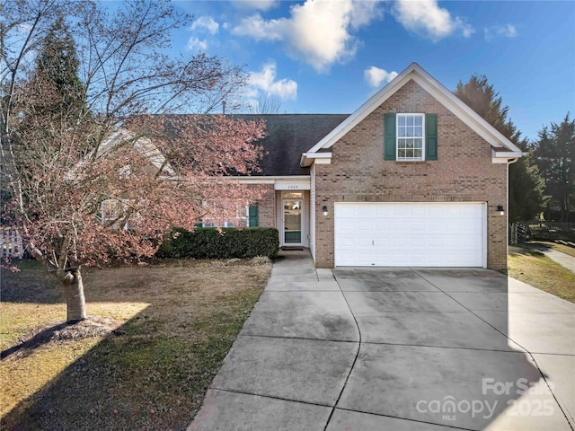 traditional-style home featuring brick siding, driveway, and an attached garage