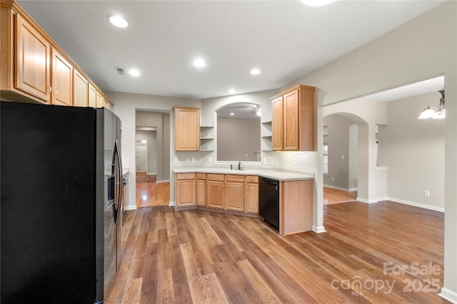 kitchen with arched walkways, open shelves, light wood-style floors, light countertops, and black appliances